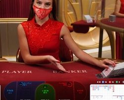 Croupière à une table de baccarat en live en direct d'un studio